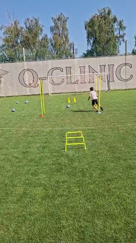 Mladý hráč beží cez prekážky a koordinačné tyče počas tréningu rýchlosti.